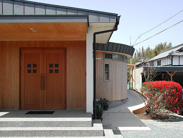 木造　菊池N邸1、玄関部分の外壁は杉板仕上げ、両開きのドアは米松です