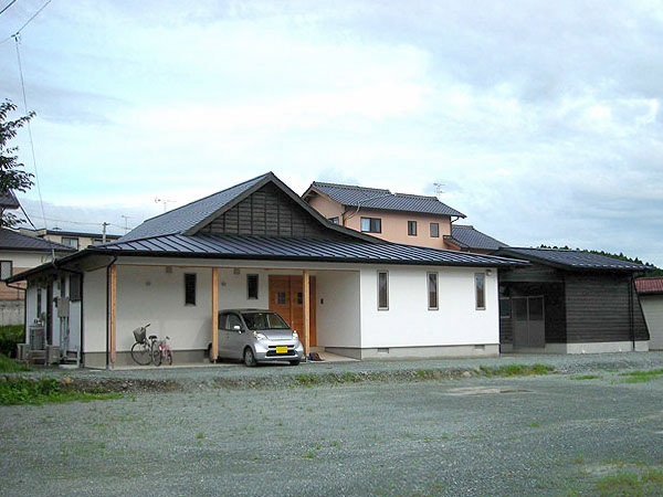木造　熊本T邸2、住まいの全景で、右側には外壁を木板で仕上げた離れの書庫があります