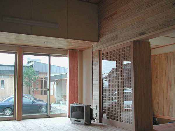 木造　菊池N邸2、玄関と天井が高いリビングを仕切る扉は格子の大型引き戸、掃き出し窓には縦型ブラインドが付きます