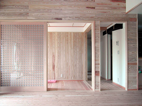 木造　菊池N邸4、玄関とリビングを仕切る格子戸は大きく、壁は玄関まで杉板で仕上げですが縦横と向きを変えています