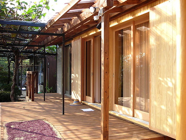 木造　熊本N邸3、ウッドデッキの半分には下屋がかかり、さらにパーゴラがつながります、リビングの大窓は木製です