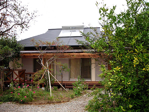 木造　熊本N邸2、正面から見た外観で、屋根にはエコロジーに配慮した太陽熱温水器が見えます