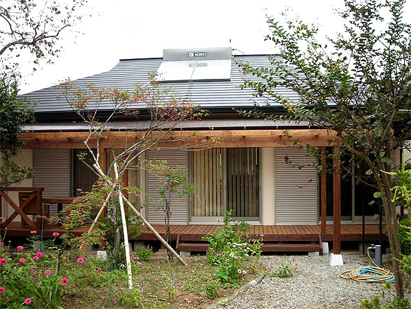 木造　熊本N邸3、正面から見た外観で、庭木に近いウッドデッキから建物にアプローチします