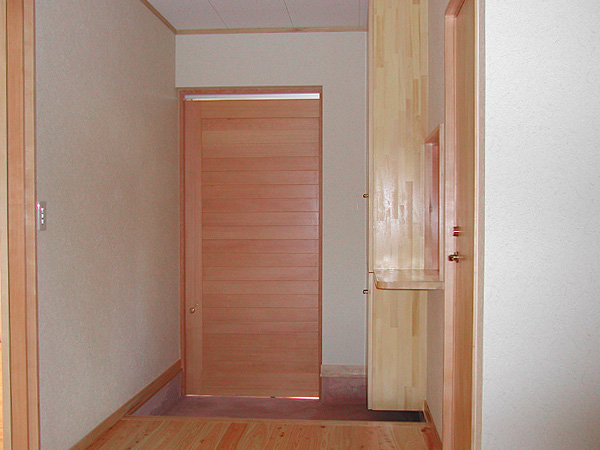 木造　城南グループホーム2、玄関ドアは木製の引き戸、玄関収納や受付カウンターも木製です
